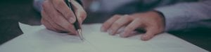 Man hands writing on a piece of paper.