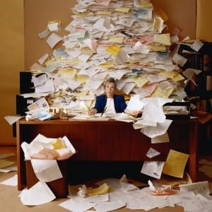 Office worker with Mountain of Paperwork