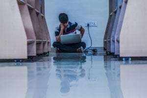 A man with his laptop in the library